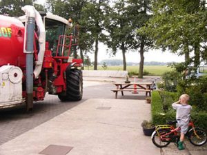 kinderen op erf met grote machines