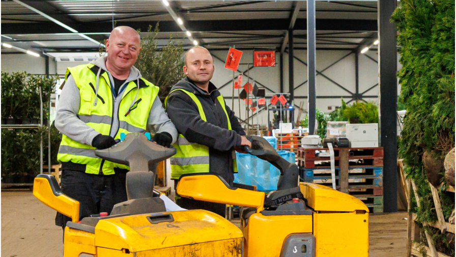 Twee mannen poseren met kleine heftrucks