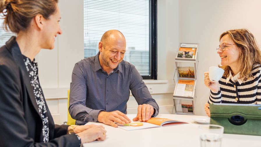 Man in conversatie aan tafel glimlacht