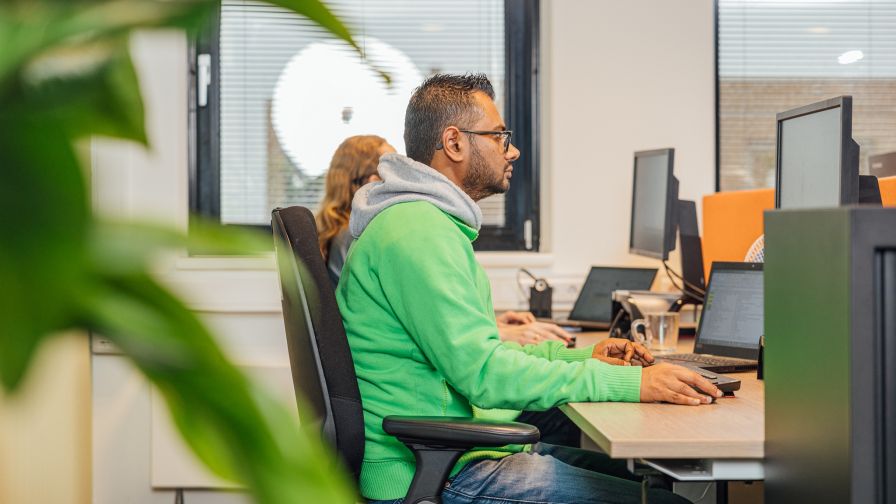 Man op bureau stoel aan het werk op een computer