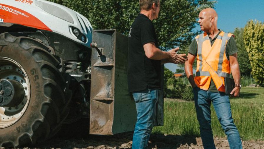 Mannen buiten naast tractor in gesprek