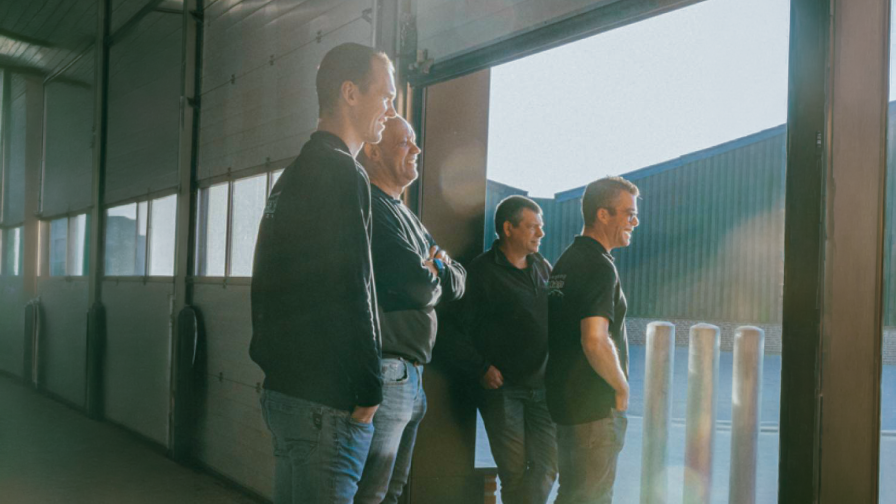 Mannen kijken vanuit een loods naar buiten